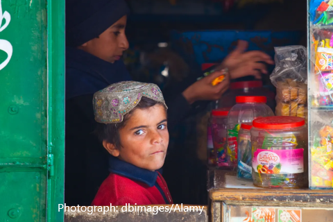 Photo of boy in corner store surrounded by junk food